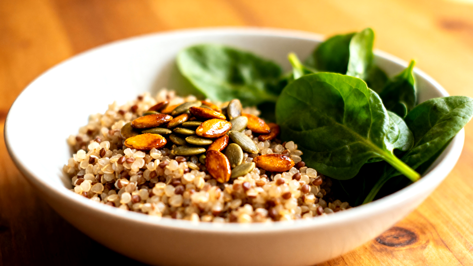 Quinoa-Buchweizen-Bowl mit gerösteten Kürbiskernen und Spinat"